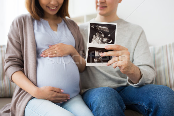 Stock photo: close up of couple with baby ultrasound images