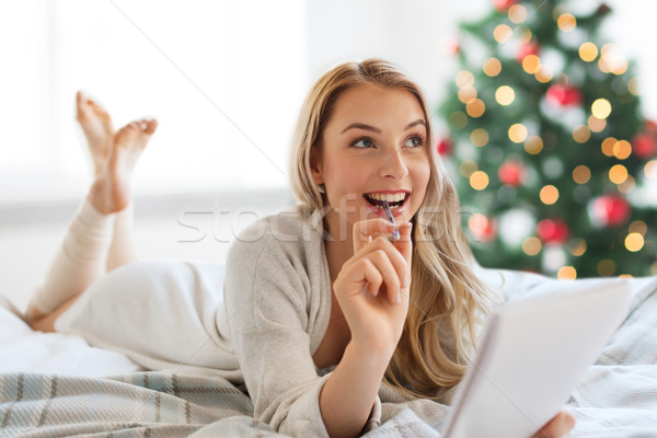 happy woman with notebook in bed at christmas Stock photo © dolgachov