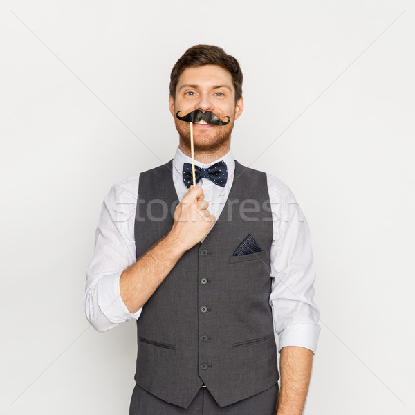 happy young man with fake mustache at party Stock photo © dolgachov