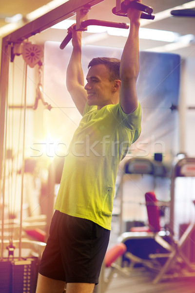 smiling man exercising in gym Stock photo © dolgachov