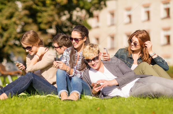 students looking at smartphones and tablet pc Stock photo © dolgachov