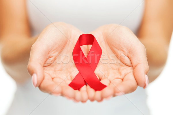 hands holding red AIDS awareness ribbon Stock photo © dolgachov