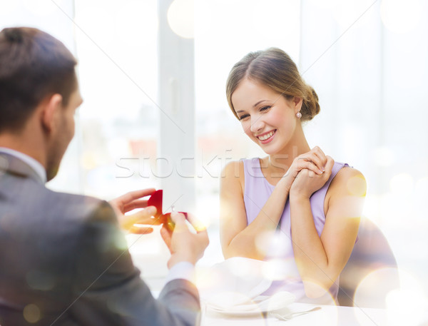 Animado mulher jovem olhando namorado anel restaurante Foto stock © dolgachov