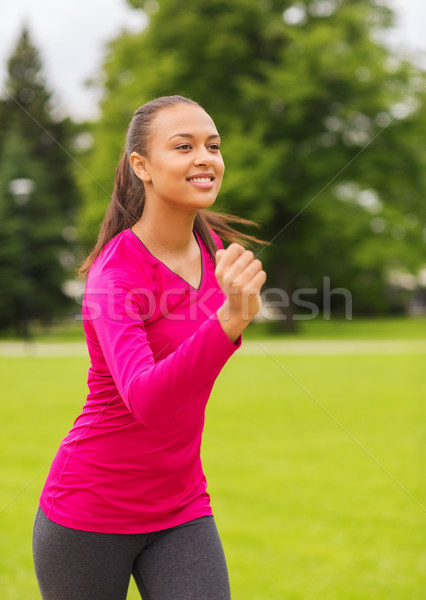 Stock photo: smiling young woman running outdoors