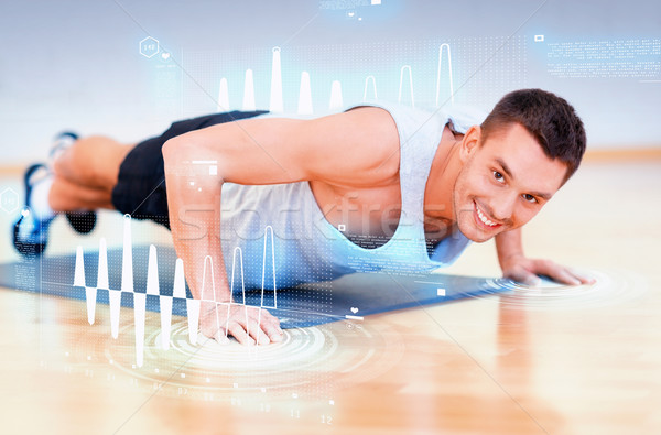 smiling man doing push-ups in the gym Stock photo © dolgachov