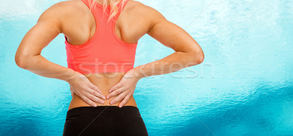 close up of sporty woman touching her back Stock photo © dolgachov