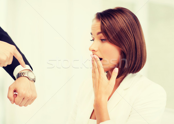 boss showing time to stressed businesswoman Stock photo © dolgachov