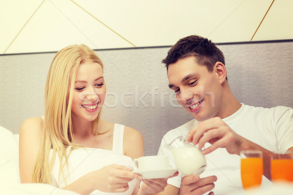 smiling couple having breakfast in bed in hotel Stock photo © dolgachov