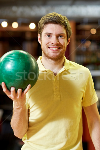 happy young man holding ball in bowling club Stock photo © dolgachov