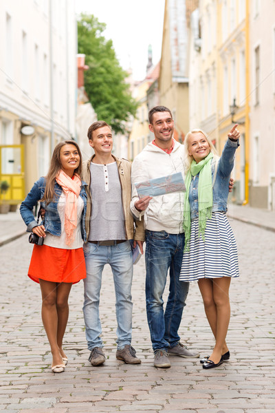 group of smiling friends with map and photocamera Stock photo © dolgachov