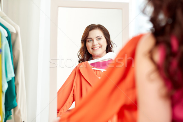 happy plus size woman with shirt at mirror Stock photo © dolgachov