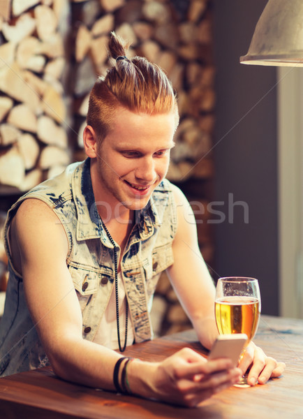 happy man with smartphone drinking beer at bar Stock photo © dolgachov
