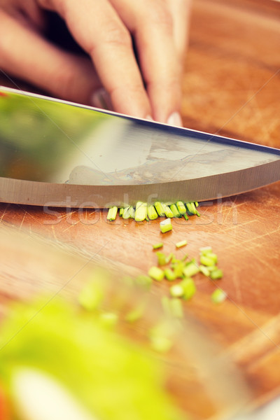 close up of woman chopping green onion with knife Stock photo © dolgachov