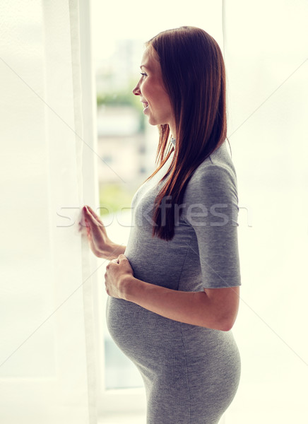 Stock photo: happy pregnant woman with big tummy at home