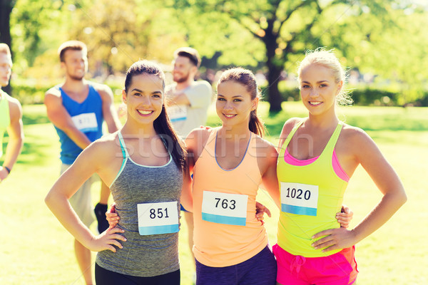 happy young sporty women with racing badge numbers Stock photo © dolgachov