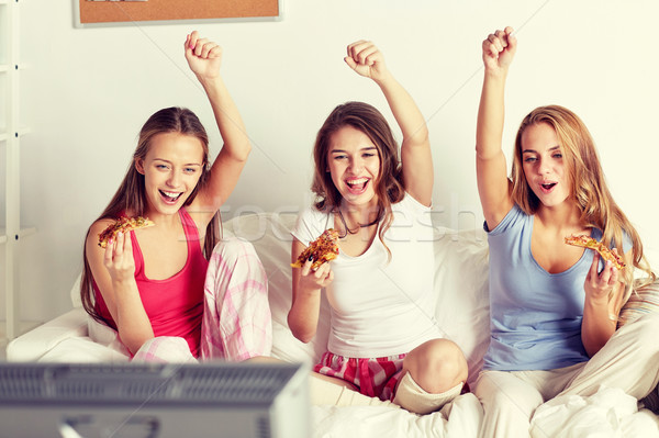 happy friends or teen girls eating pizza at home Stock photo © dolgachov