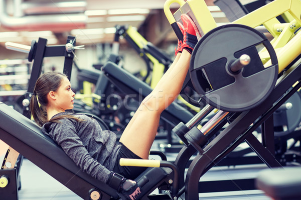 Mujer músculos pierna prensa máquina gimnasio Foto stock © dolgachov