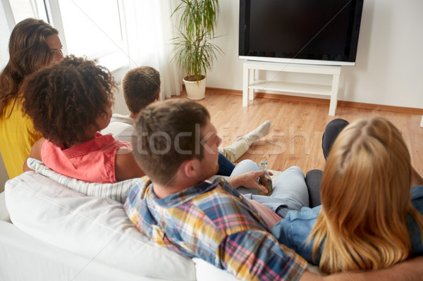 friends with beer watching tv at home Stock photo © dolgachov