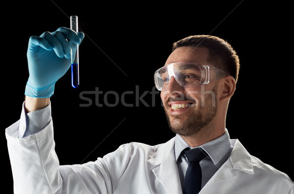 smiling scientist in safety glasses with test tube Stock photo © dolgachov