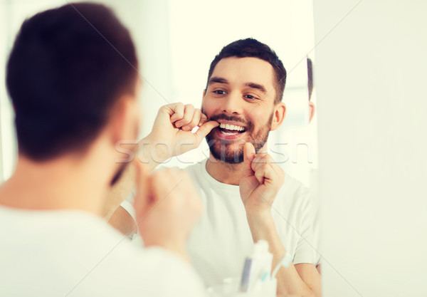 Mann Zahnseide Reinigung Zähne Bad Gesundheitspflege Stock foto © dolgachov