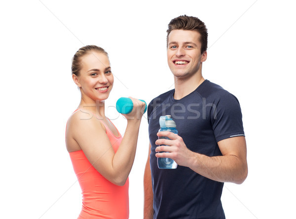 sportive man and woman with dumbbell and water Stock photo © dolgachov