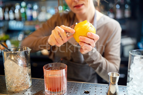 bartender peels orange peel for cocktail at bar Stock photo © dolgachov