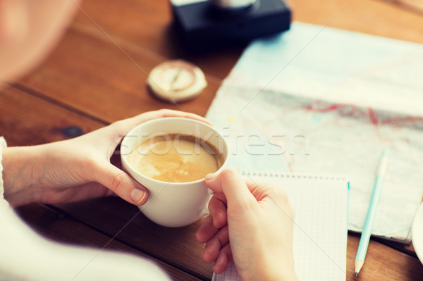 close up of hands with coffee cup and travel stuff Stock photo © dolgachov