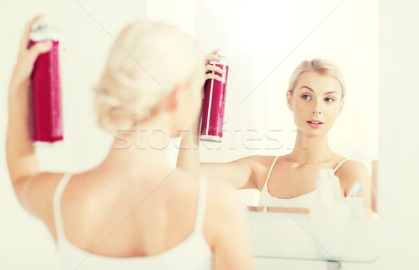 woman with hairspray styling her hair at bathroom Stock photo © dolgachov