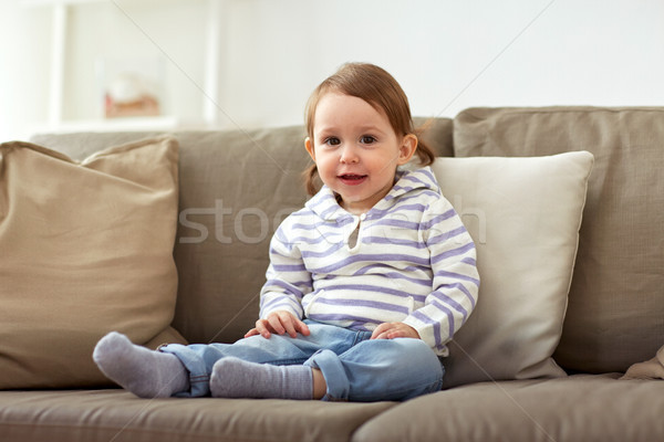 happy smiling baby girl sitting on sofa at home Stock photo © dolgachov
