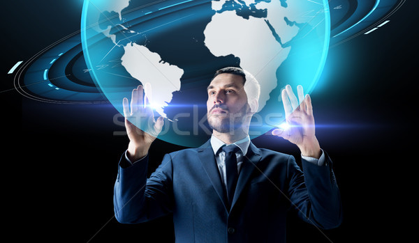 Stock photo: businessman with earth hologram over black