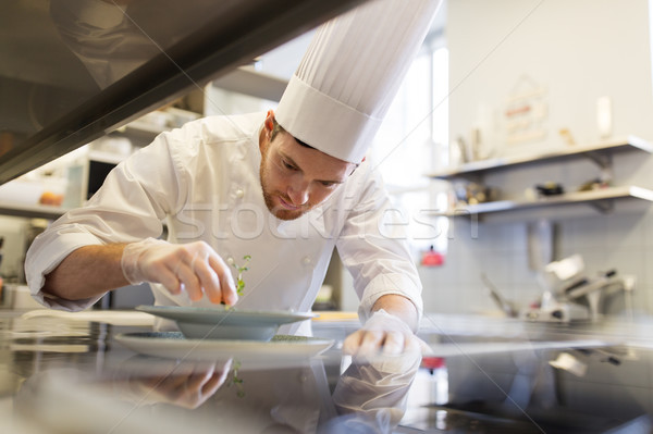 happy male chef cooking food at restaurant kitchen Stock photo © dolgachov