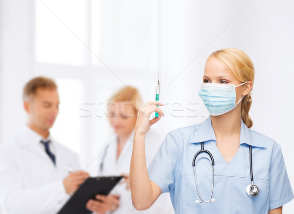 Feminino médico enfermeira máscara seringa Foto stock © dolgachov