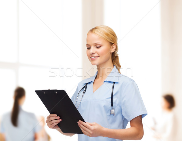 smiling female doctor or nurse with clipboard Stock photo © dolgachov