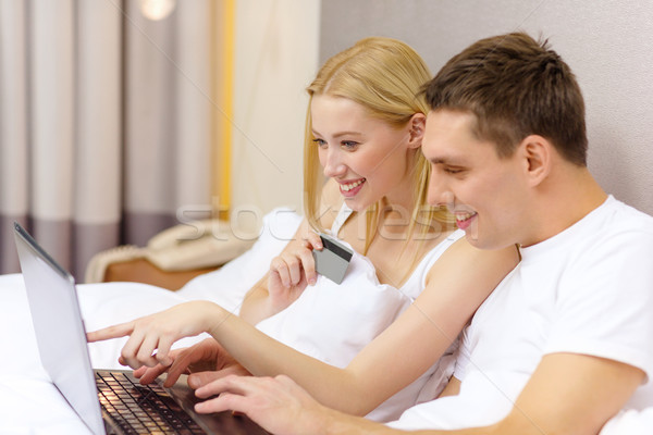 Stock photo: couple in bed with laptop computer and credit card