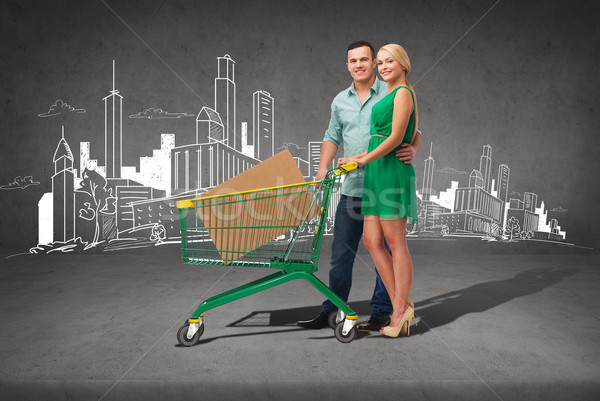 smiling couple with shopping cart and big box Stock photo © dolgachov