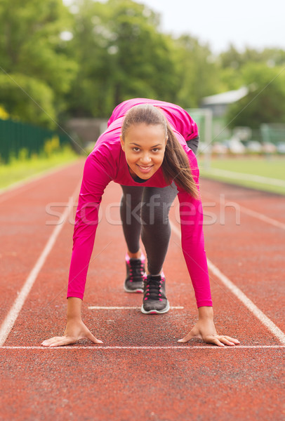 smiling young woman running on track outdoors Stock photo © dolgachov