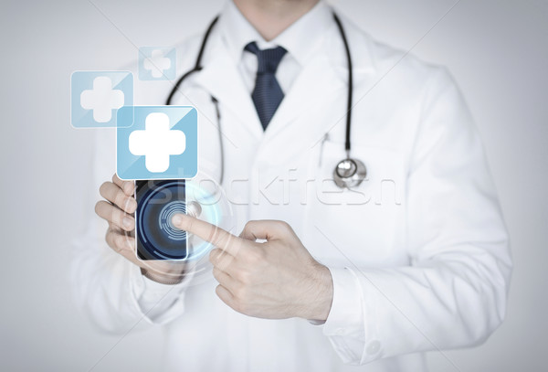 doctor holding smartphone with medical app Stock photo © dolgachov