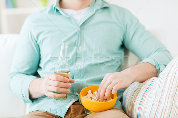 close up of man with popcorn and beer at home Stock photo © dolgachov