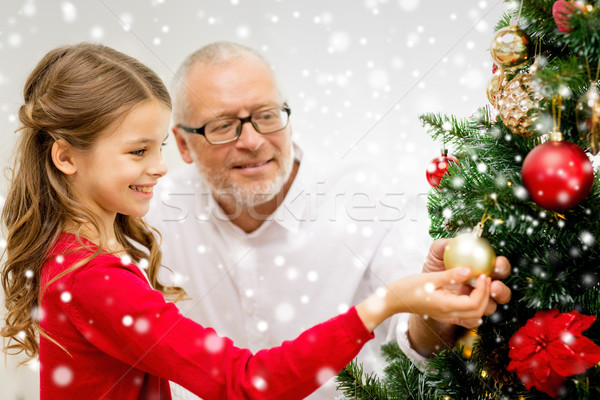 smiling family decorating christmas tree at home Stock photo © dolgachov