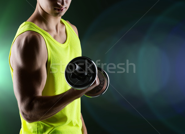 close up of young man with dumbbell flexing biceps Stock photo © dolgachov