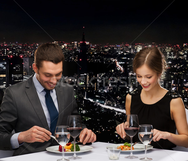 smiling couple eating main course at restaurant Stock photo © dolgachov