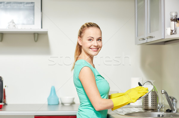 Stock photo: happy woman washing dishes at home kitchen