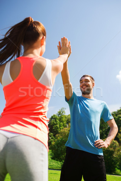 Dwa uśmiechnięty ludzi high five odkryty Zdjęcia stock © dolgachov