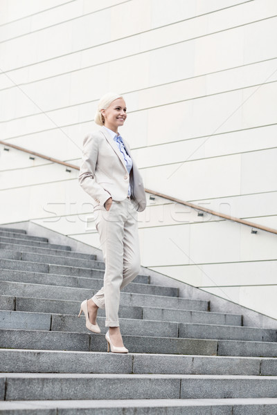 young smiling businesswoman walking down stairs Stock photo © dolgachov