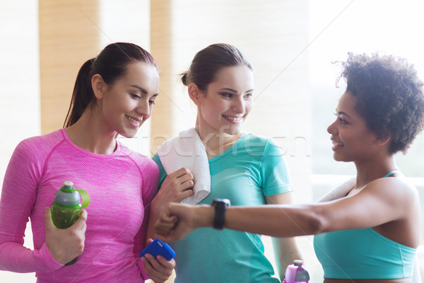happy women showing time on wrist watch in gym Stock photo © dolgachov