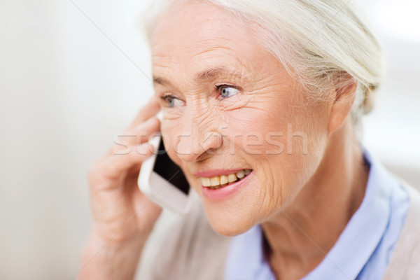 senior woman with smartphone calling at home Stock photo © dolgachov
