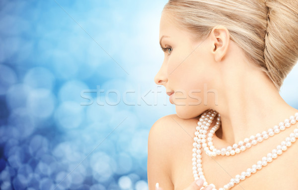 beautiful woman with sea pearl necklace over blue Stock photo © dolgachov