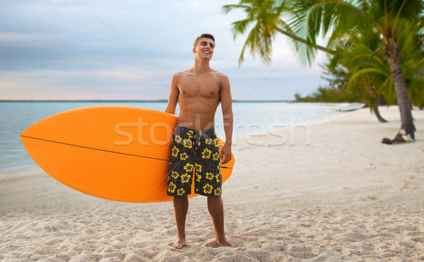 smiling young man with surfboard on summer beach Stock photo © dolgachov