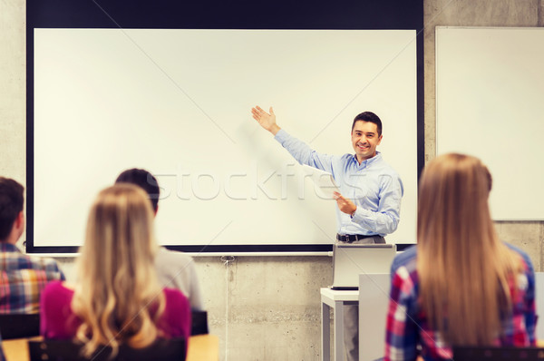 group of students and smiling teacher with notepad Stock photo © dolgachov