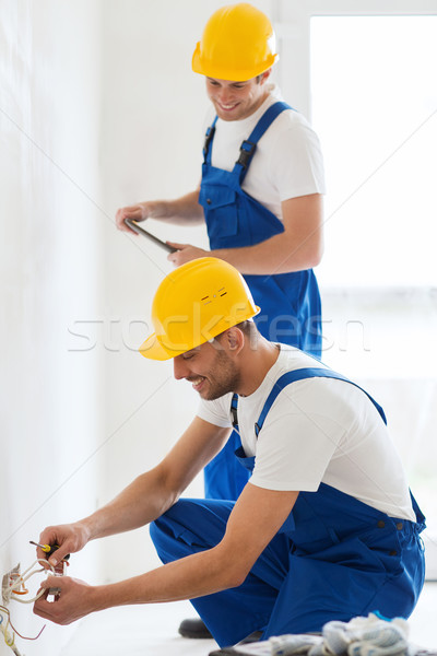 builders with tablet pc and fixing wiring indoors Stock photo © dolgachov
